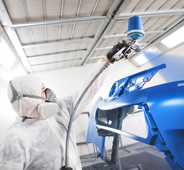 technician in spray booth after collision repair at Mills Collision Center