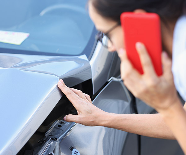 woman calling Mills Collision Center for help with insurance claim
