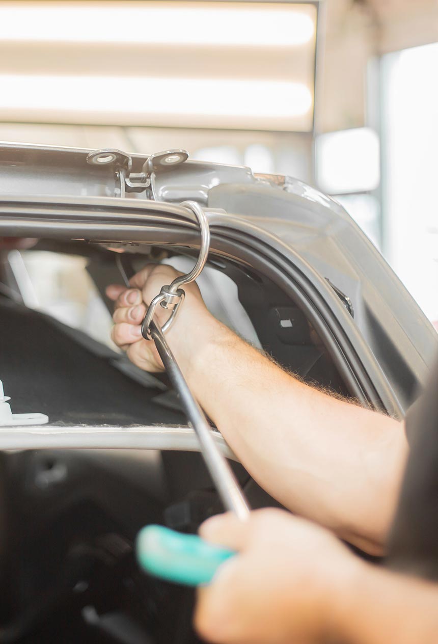 paintless dent repair professional removing dent from car at Mills Collision Center